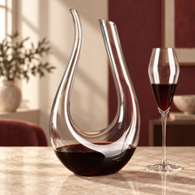 The Curved Pour Swan Decanter with a glass of red wine